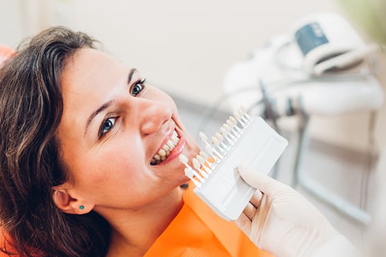 patient on dental chair with dentist providing teeth whitening options